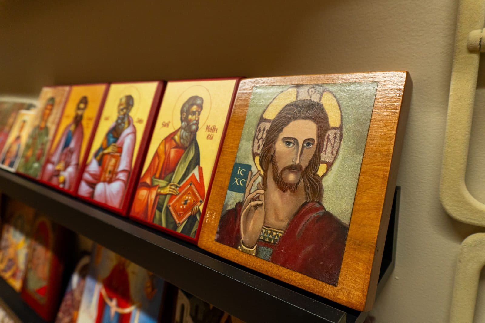 Framed Byzantine icons displayed together on a warmly lit store shelf