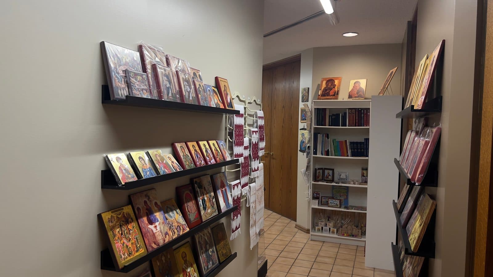 Store aisle displaying Byzantine icons, embroidered textiles, books, and religious gifts