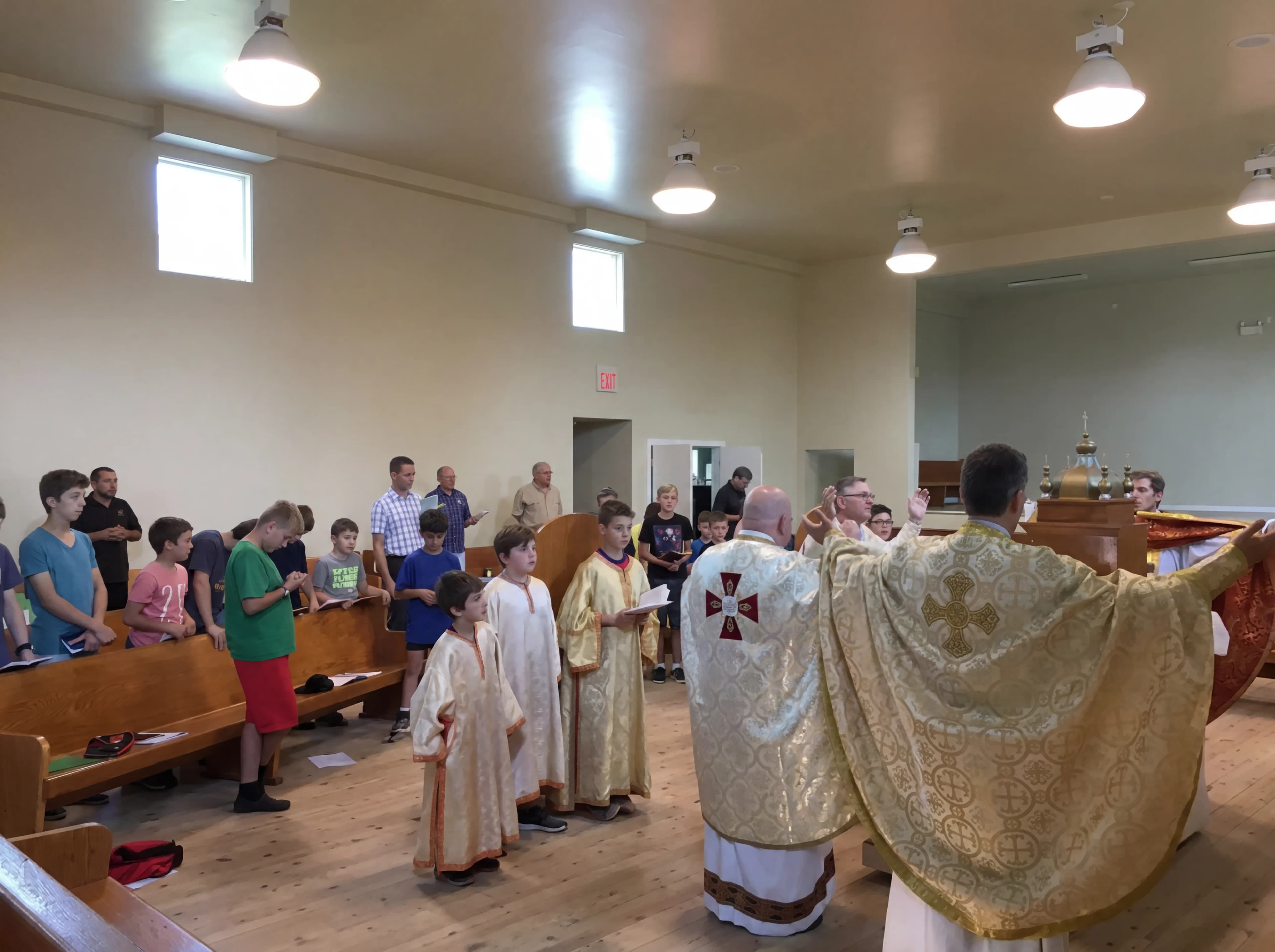 Priests in ornate vestments lead a children's choir during a Divine Liturgy.