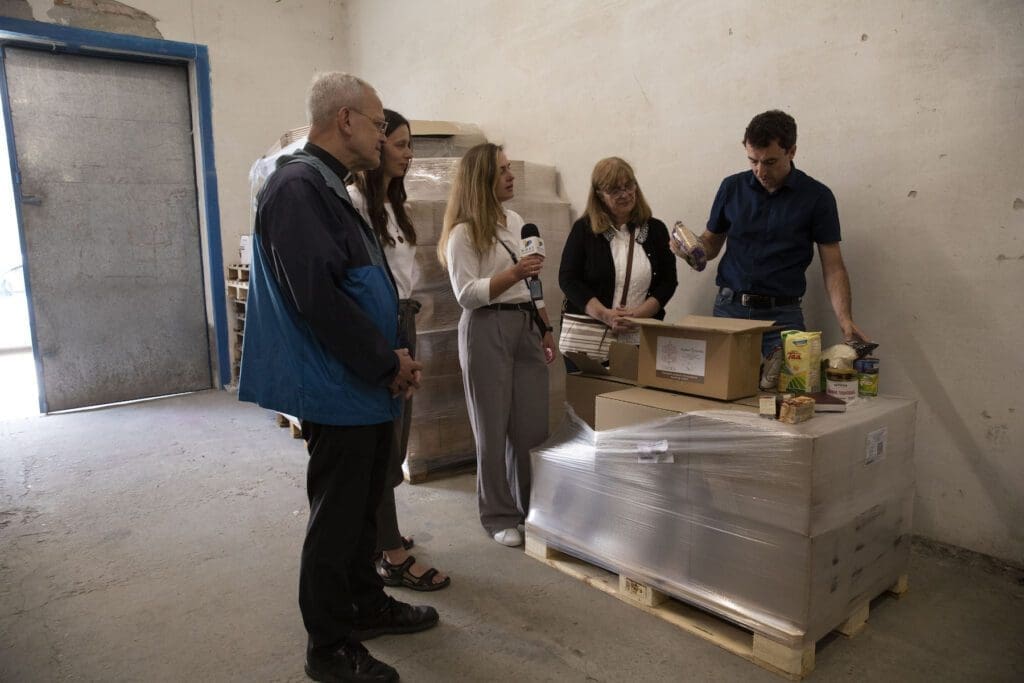 Msgr. Peter I. Vaccari, Adriana Bara and Anna Dombrovska visit a CNEWA-sponsored food box program Novoyavorivsk, Ukraine. (photo: Oleksandr Savranskiy)